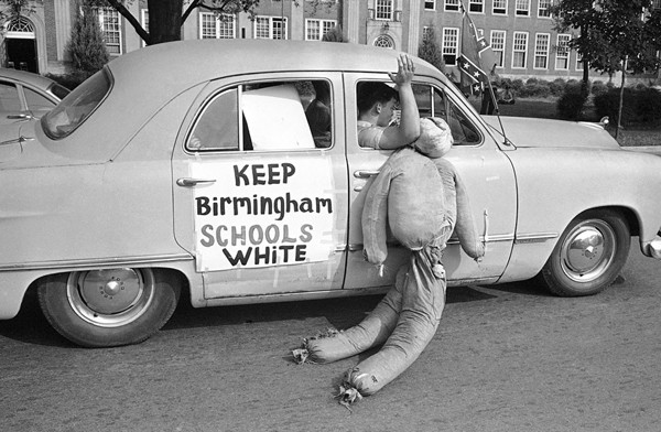 White students in Birmingham, Alabama, drag an Black effigy past West End High School, on September 12, 1963. Two Black girls attended the desegregated school and a majority of the white students were staying away from classes. Police stopped this car in a segregationist caravan in front of the school to caution them about fast driving and blowing auto horns in front of a school. 